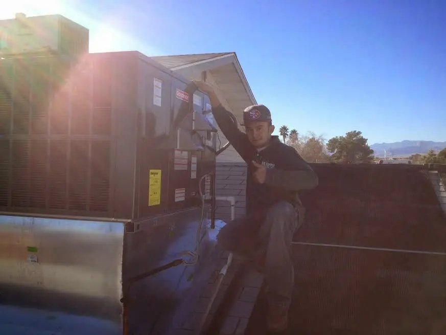 HVAC technician performing Air Duct Cleaning on a rooftop unit in Kentwood